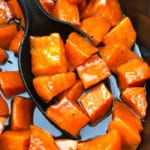 Big Spoonful of Candied Sweet Potatoes in Black Crockpot