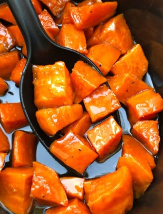 Big Spoonful of Candied Sweet Potatoes in Black Crockpot
