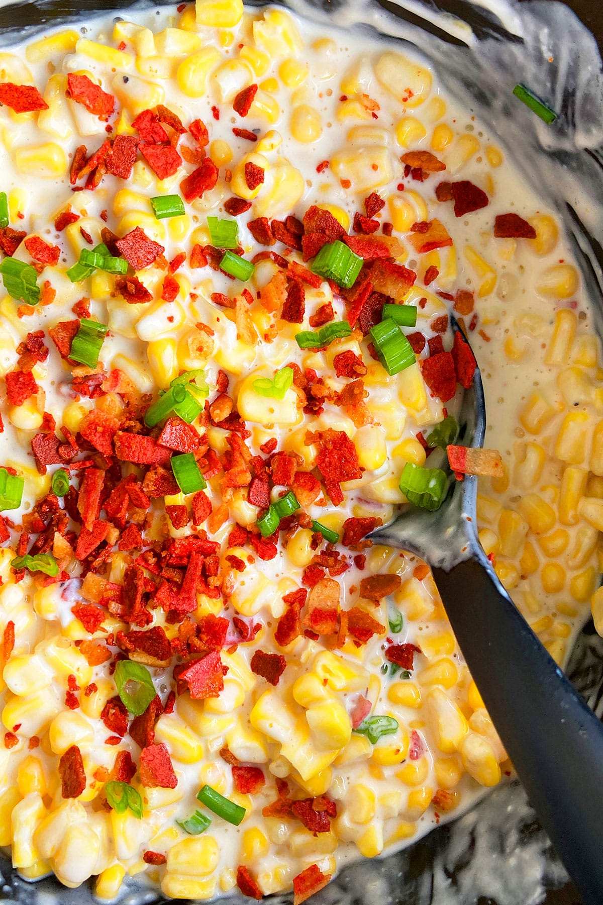 Easy Creamed Corn with Bacon in Black Slow Cooker.