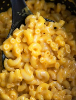 Spoonful of Easy Mac and Cheese in Black Slow Cooker
