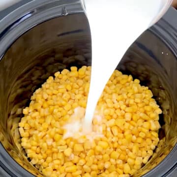 Milk being poured in black crockpot. 