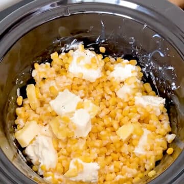 Cubes of butter and cheese on top of corn. 