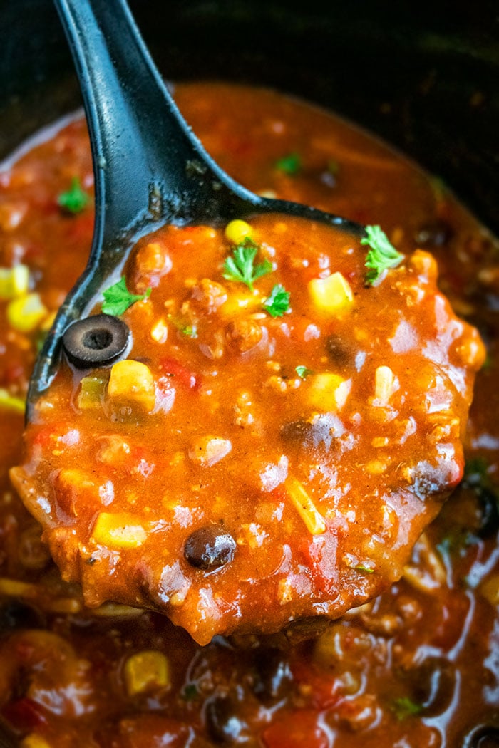 Spoonful of Homemade Chili in Black Crockpot