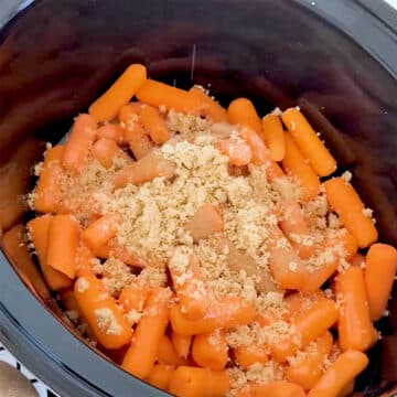 Spices and brown sugar being added to baby carrots.