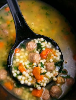 Easy Homemade Italian Wedding Soup in Black Slow Cooker with Black Spoon
