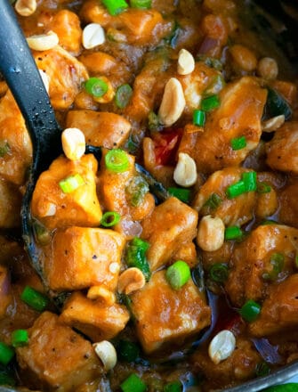 Spoonful of Easy Thai Peanut Chicken in Black Slow Cooker