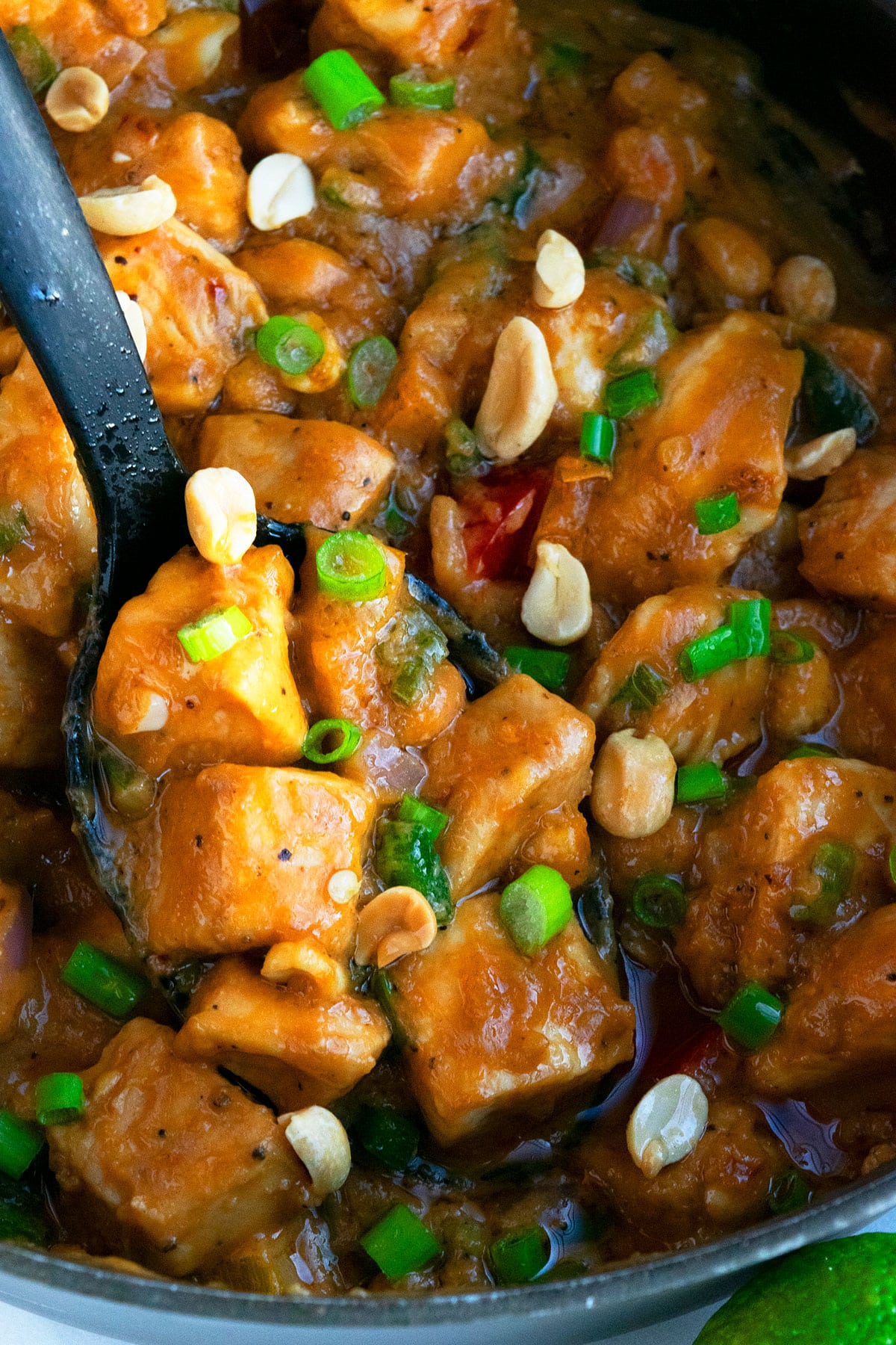 Big Spoonful of Thai Peanut Chicken in Black Slow Cooker.