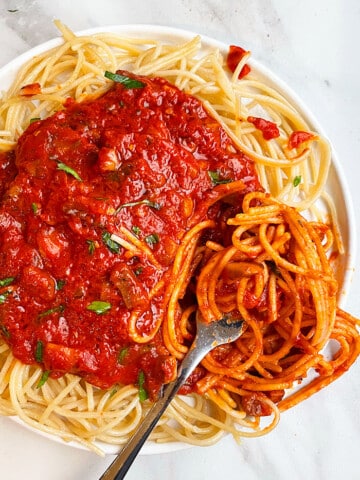 Easy Slow Cooker Vegetarian Mushroom Bolognese Served Over Pasta in White Plate