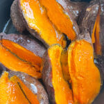Easy Homemade Baked Sweet Potatoes Sliced in Half in Black Crockpot