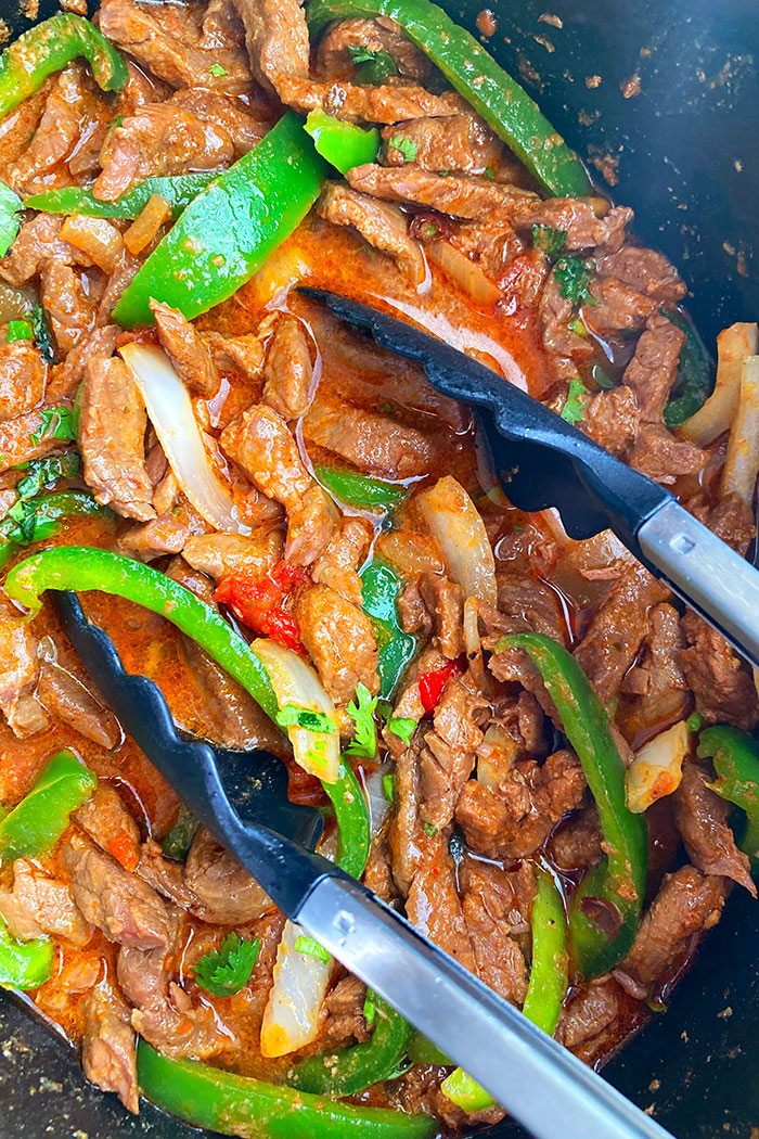 Tongs Full of Best Mexican Beef in Crockpot 