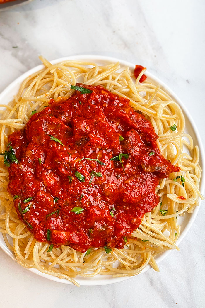 Best Crockpot Veggie Bolognese Served in White Plate Over Spaghetti - Overhead Shot
