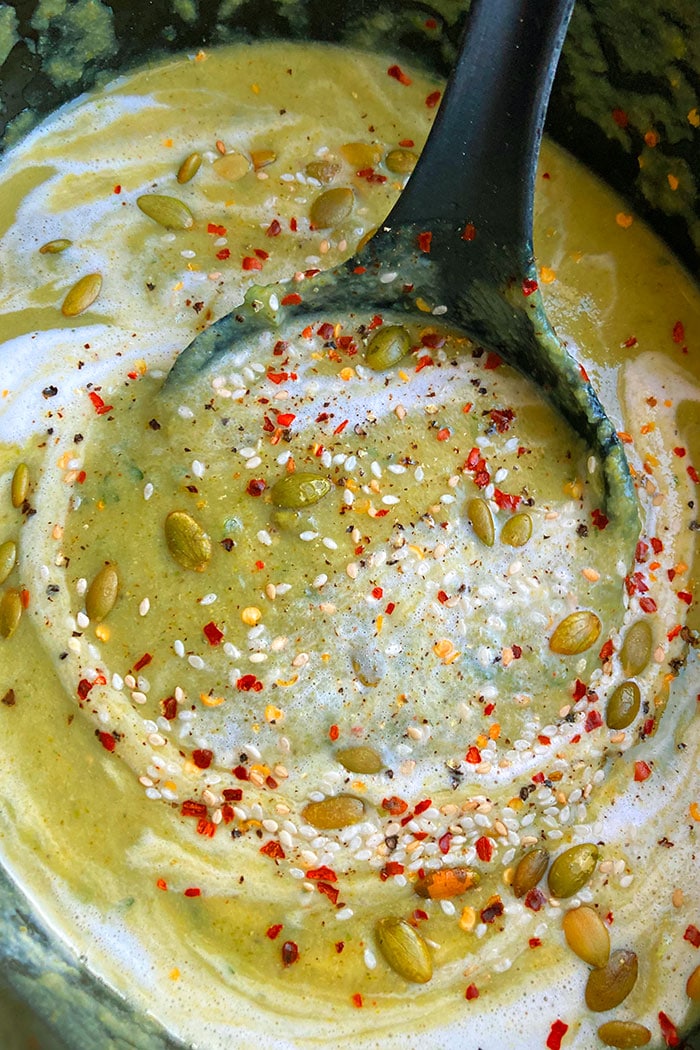 Spoonful of Creamy Vegetarian Broccoli Soup With Pumpkin Seeds and Heavy Cream