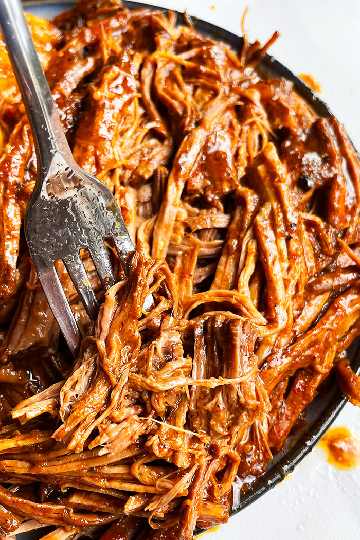 Shredded Meat With Barbecue Sauce in Plate With Fork