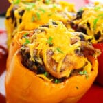 Slow Cooker Stuffed Bell Peppers With Rice, Cheese and Ground Beef Served in Red Plate