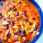 Easy Slow Cooker Mexican Chicken Enchilada Soup Served in Blue Bowl on Marbled Background