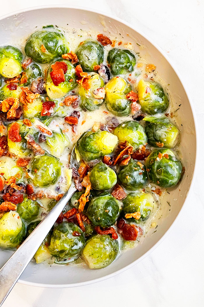 Slow Cooker Creamy Brussels Sprouts With Bacon Served in in Gray Bowl