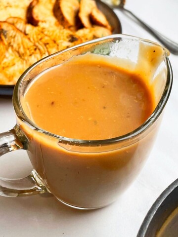 Easy Homemade Slow Cooker Brown Turkey Gravy From Drippings in Glass Cup