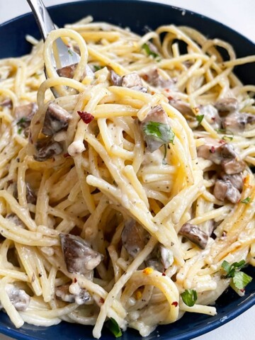 Easy Creamy Slow Cooker Chicken and Mushroom Pasta Served in Blue Bowl