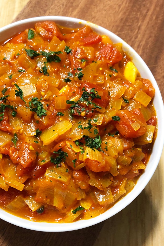 Slow Cooker Stewed Tomatoes in White Bowl on Rustic Wood Background