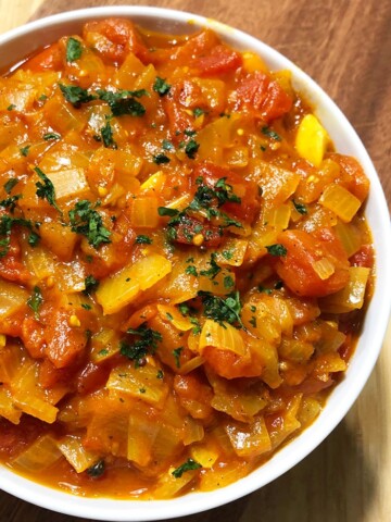 Slow Cooker Stewed Tomatoes in White Bowl on Rustic Wood Background