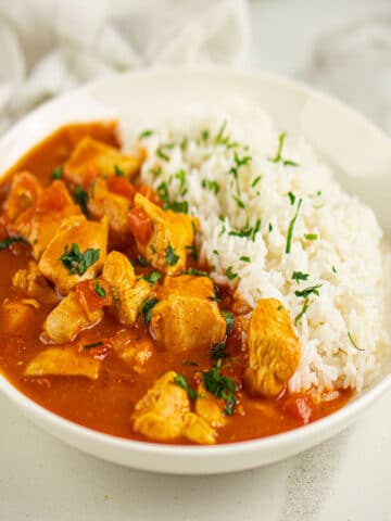 Easy Slow Cooker Paprika Chicken (Paprikash) Served in White Bowl With Rice.