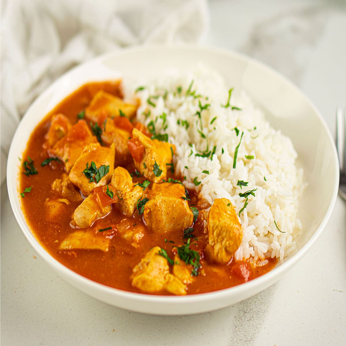 Easy Slow Cooker Paprika Chicken (Paprikash) Served in White Bowl With Rice.