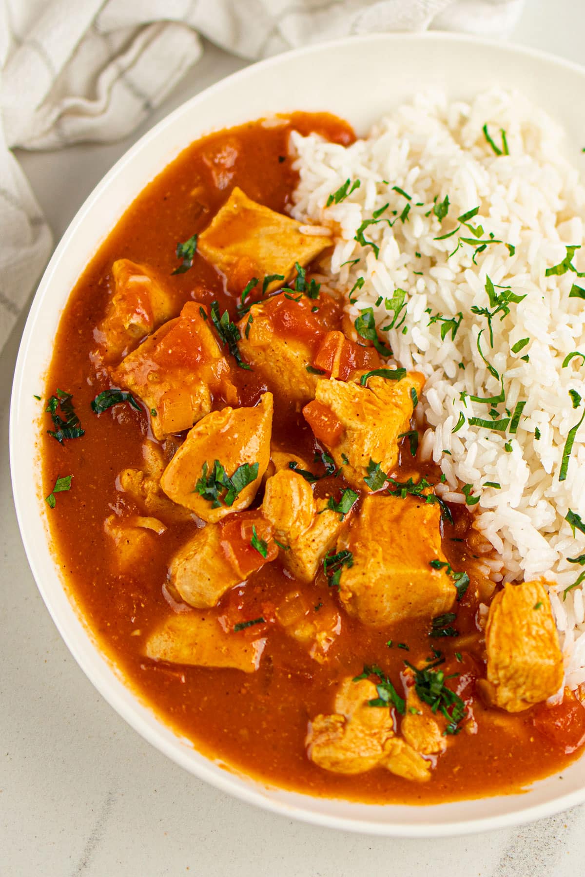 Overhead Shot of Chicken With Creamy Sauce in White Bowl Along With Rice.