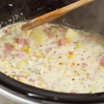 Ingredients being mixed in slow cooker until soup is thick and creamy.