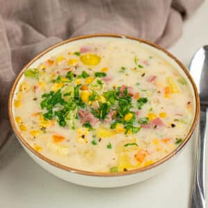 Bowl of Slow Cooker Corn Chowder With Fresh Parsley Garnish.