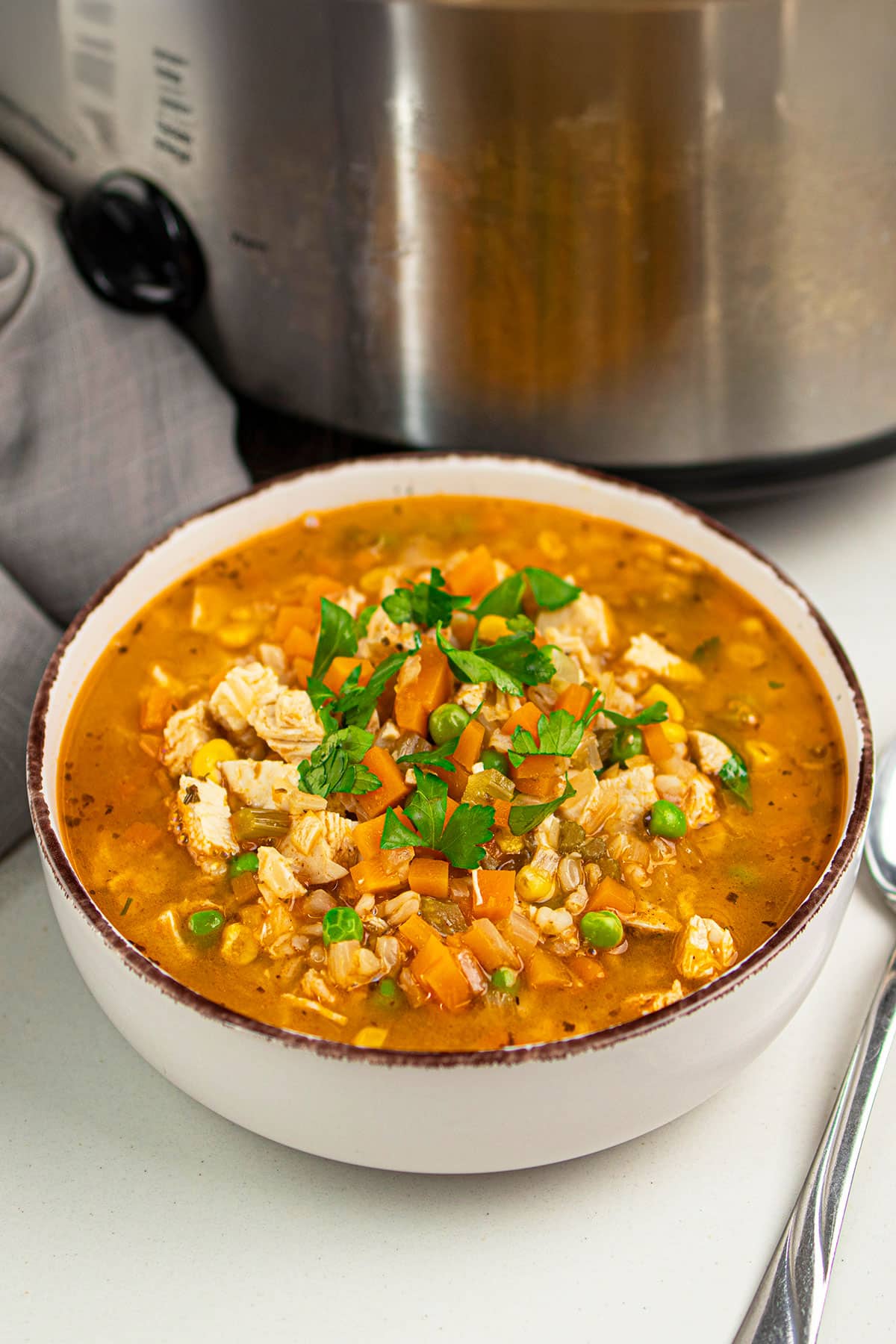 Bowl of hearty soup on white table.