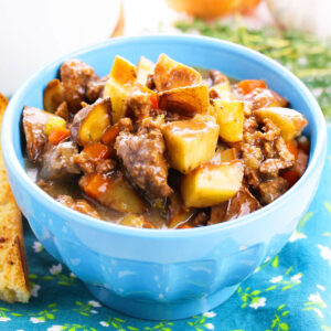 Easy slow cooker ground beef stew or poor man's stew served in blue bowl.