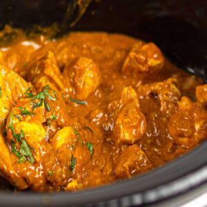 Closeup shot of easy slow cooker chicken tikka masala with cilantro garnish.