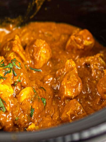 Closeup shot of easy slow cooker chicken tikka masala with cilantro garnish.